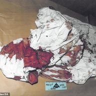 A cardboard box containing a neatly folded, very bloody man’s suit